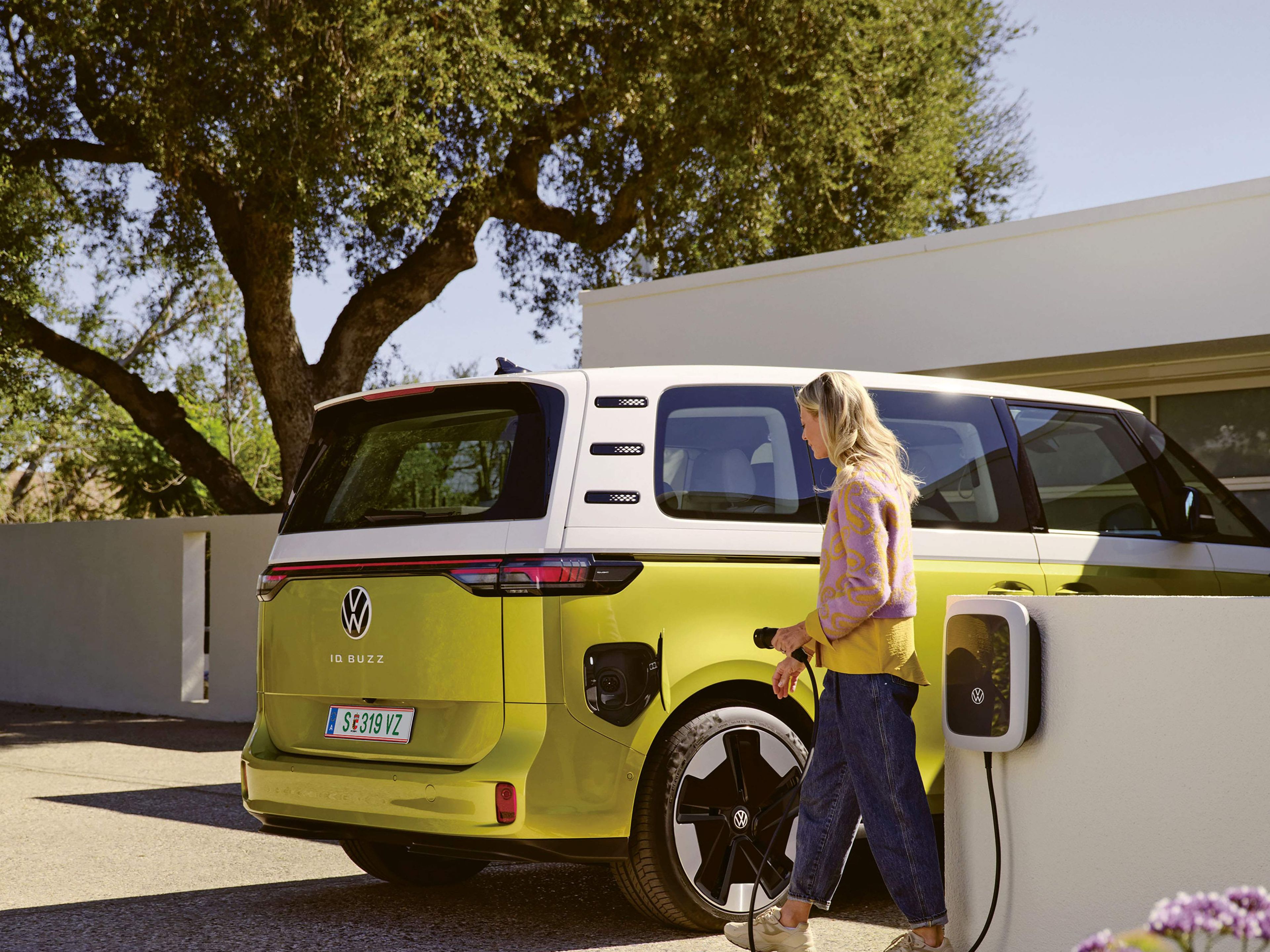 O femeie încarcă un VW ID. Buzz cu curent