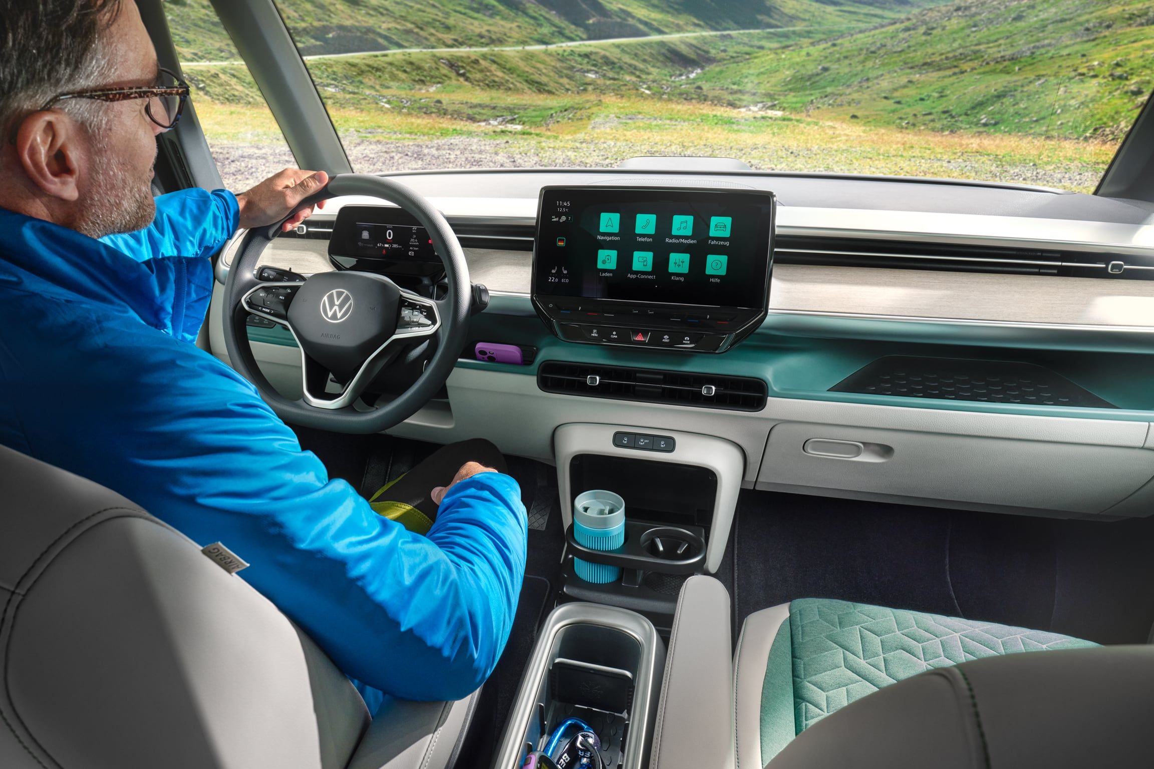 Ein Fahrer sitzt am Steuer des VW ID. Buzz mit Blick auf eine Bergstraße