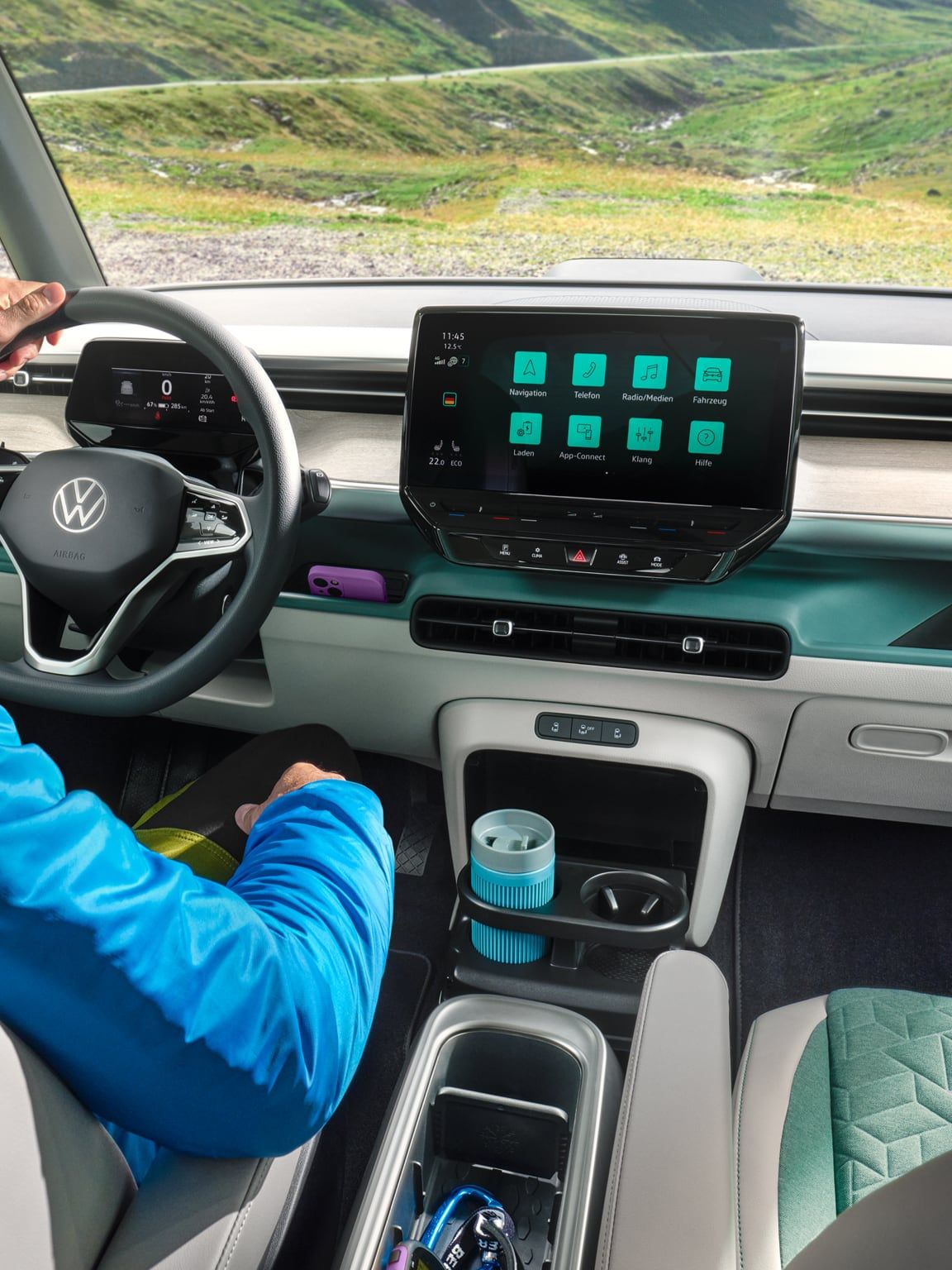 Ein Fahrer sitzt am Steuer des VW ID. Buzz mit Blick auf eine Bergstraße