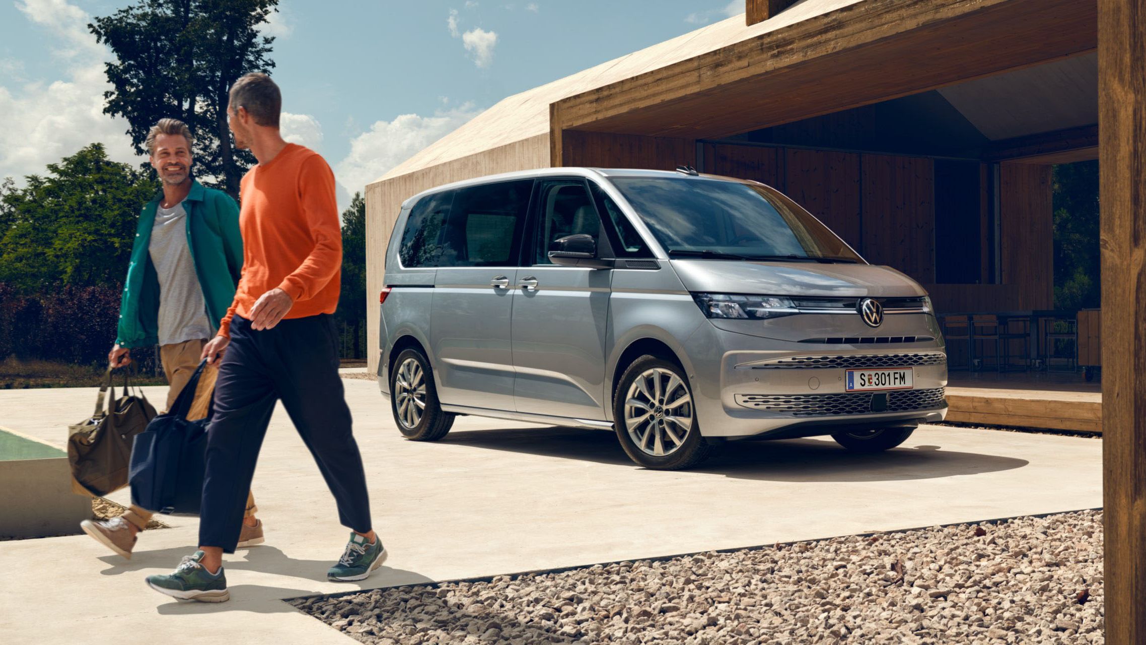 VW Multivan in silber parkt und 2 Männer bewegen sich von ihm fort