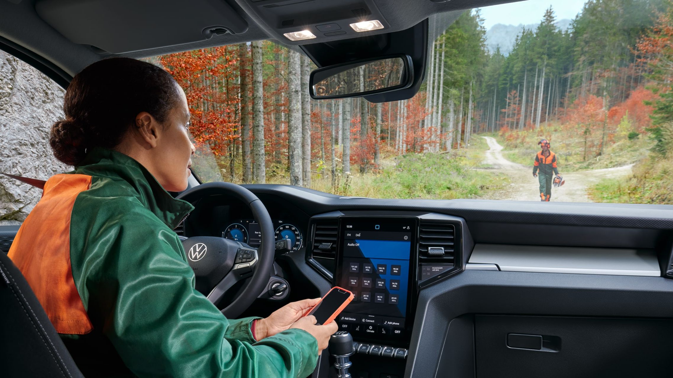 Ein Familienvater öffnet die Heckklappe eines bronzenen VW Caddy.