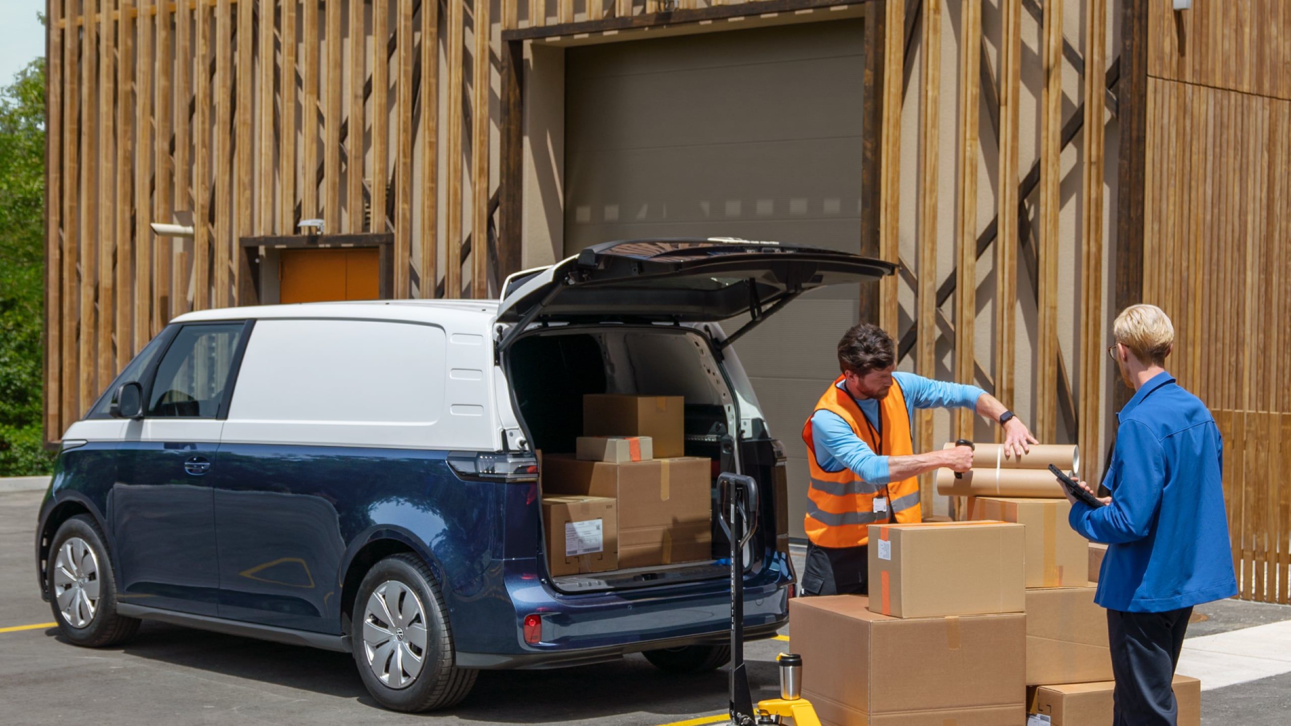Ein blau weißer ID. Buzz Cargo wird mit Paketen von einem Hubwagen beladen
