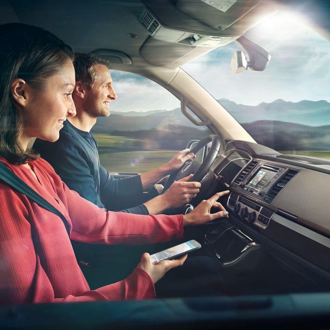 Ein Pärchen sitzt im Cockpit in einem VW-Nutzfahrzeug