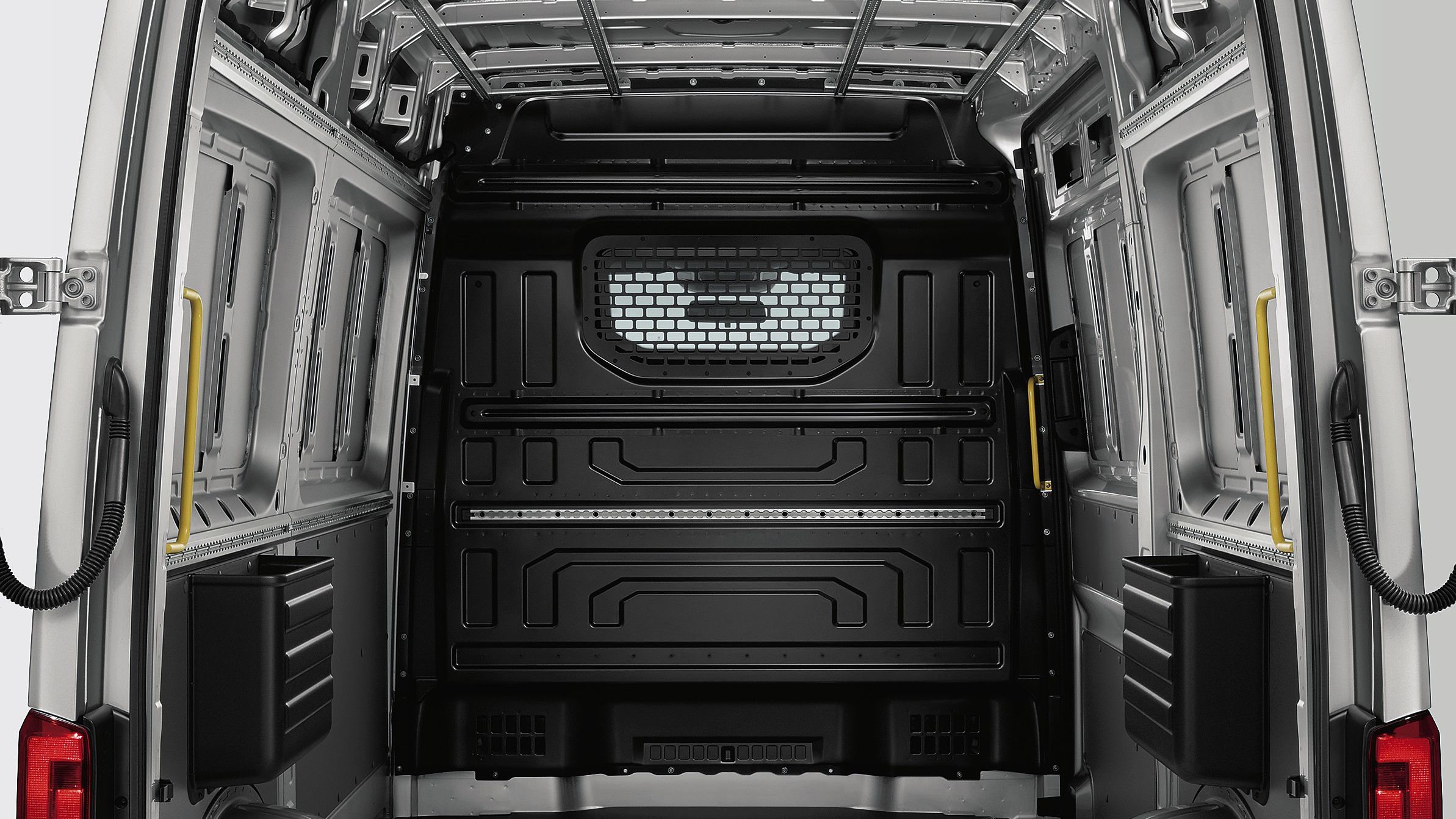 O privire în spațiul de încărcare al modelului VW Crafter autofurgon. În acesta poate fi văzut peretele despărțitor cu geamuri și grilaj de protecție.