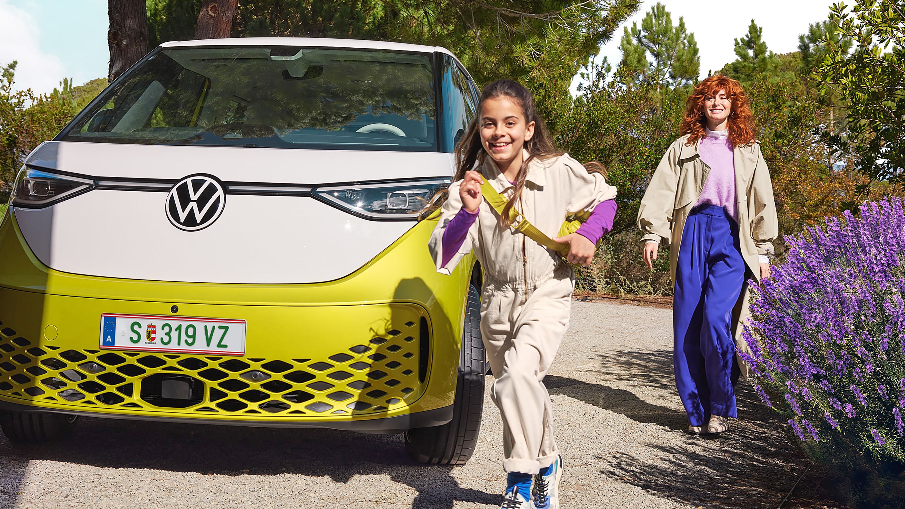 VW ID. Buzz galben cu femeie și copil care aleargă