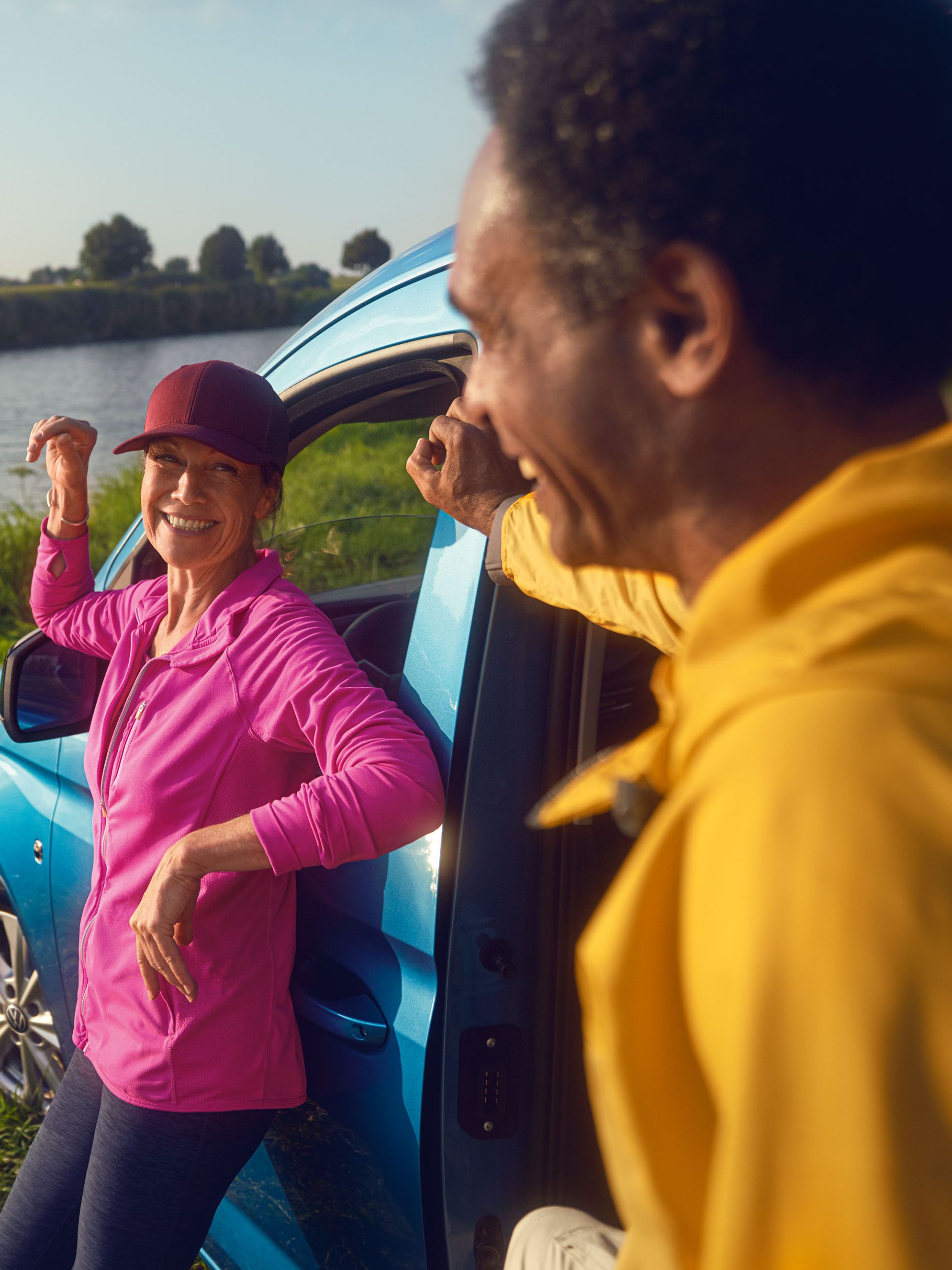 Frau lehnt an blauem VW Golf R Motorhaube